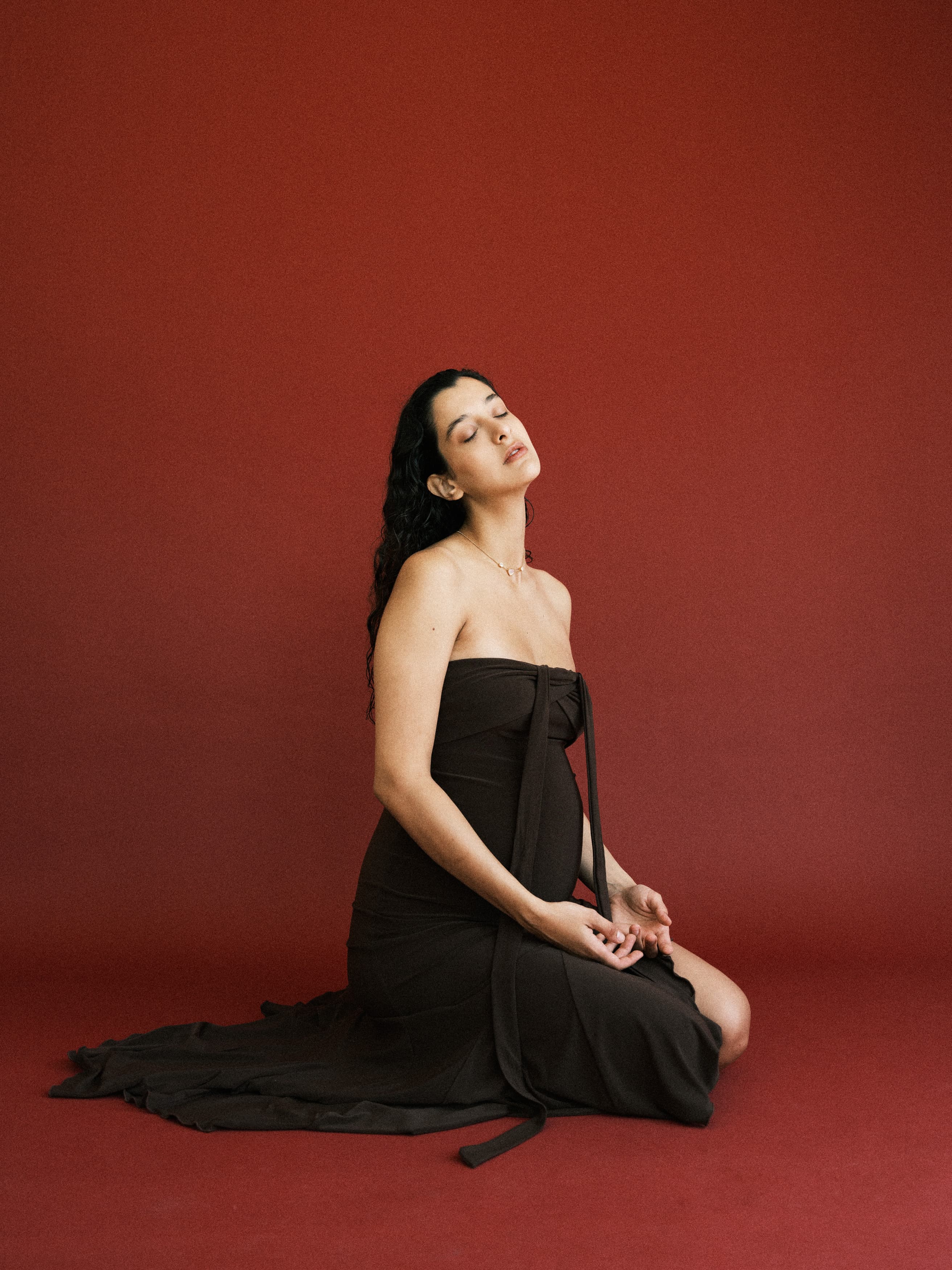 Woman in a flowing dress sitting in a meditative pose